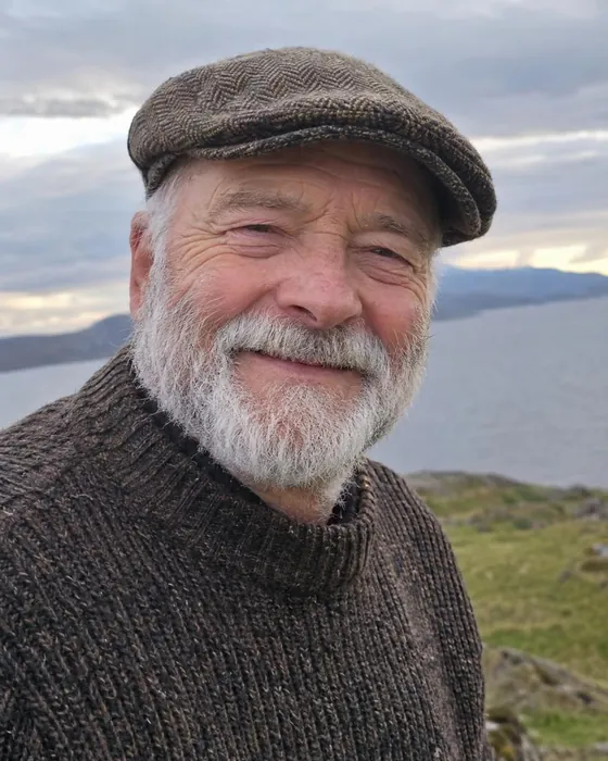 Photo of a smiling grandfather in a flat cap